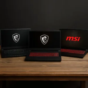 Three MSI 17-inch gaming laptops with vibrant screens and RGB-lit keyboards, positioned on a sleek black desk in a modern gaming setup.