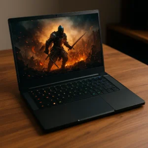 A high-resolution digital photograph showcases a Razer Blade 14 gaming laptop on a wooden desk, with its RGB keyboard lit and the screen displaying a vivid twilight mountain scene.