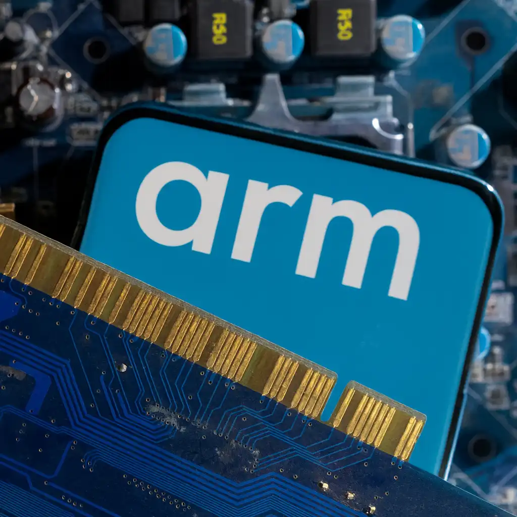A close-up view of an ARM processor logo placed against a laptop motherboard and circuit components, illustrating ARM-based architecture used in Snapdragon chips.